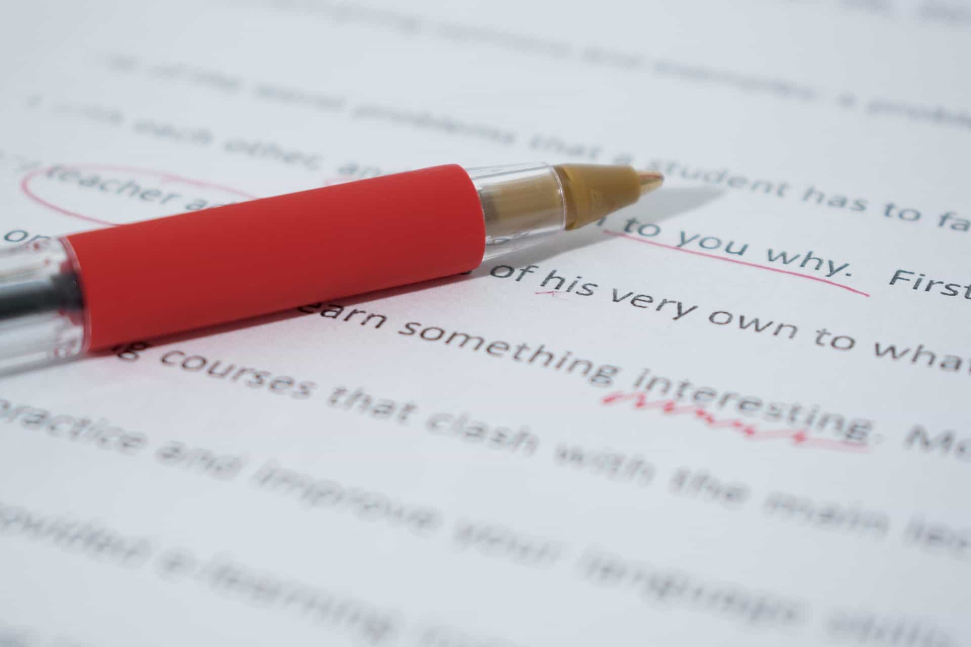 Red pen on essay with corrective marks.