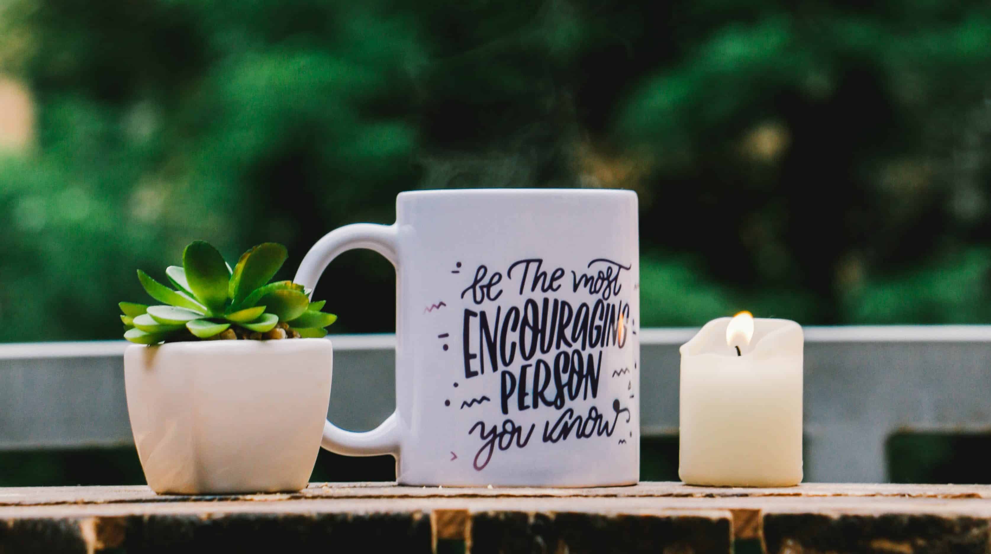 Be The Most Encouraging Person You Know mug with potted succulent and candle.
