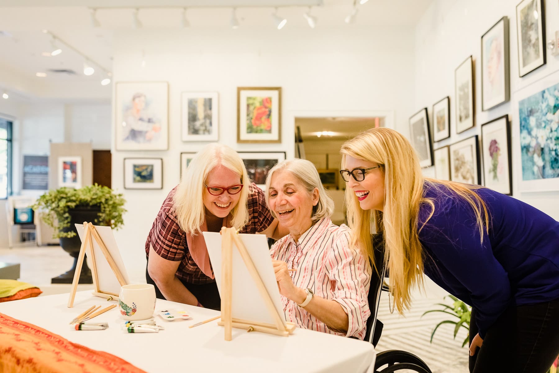 team members and resident painting in an art gallery