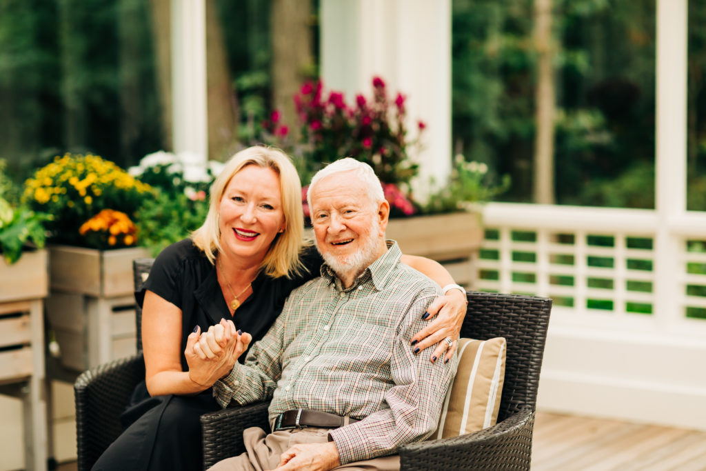 elderly man and adult woman sitting in patio together