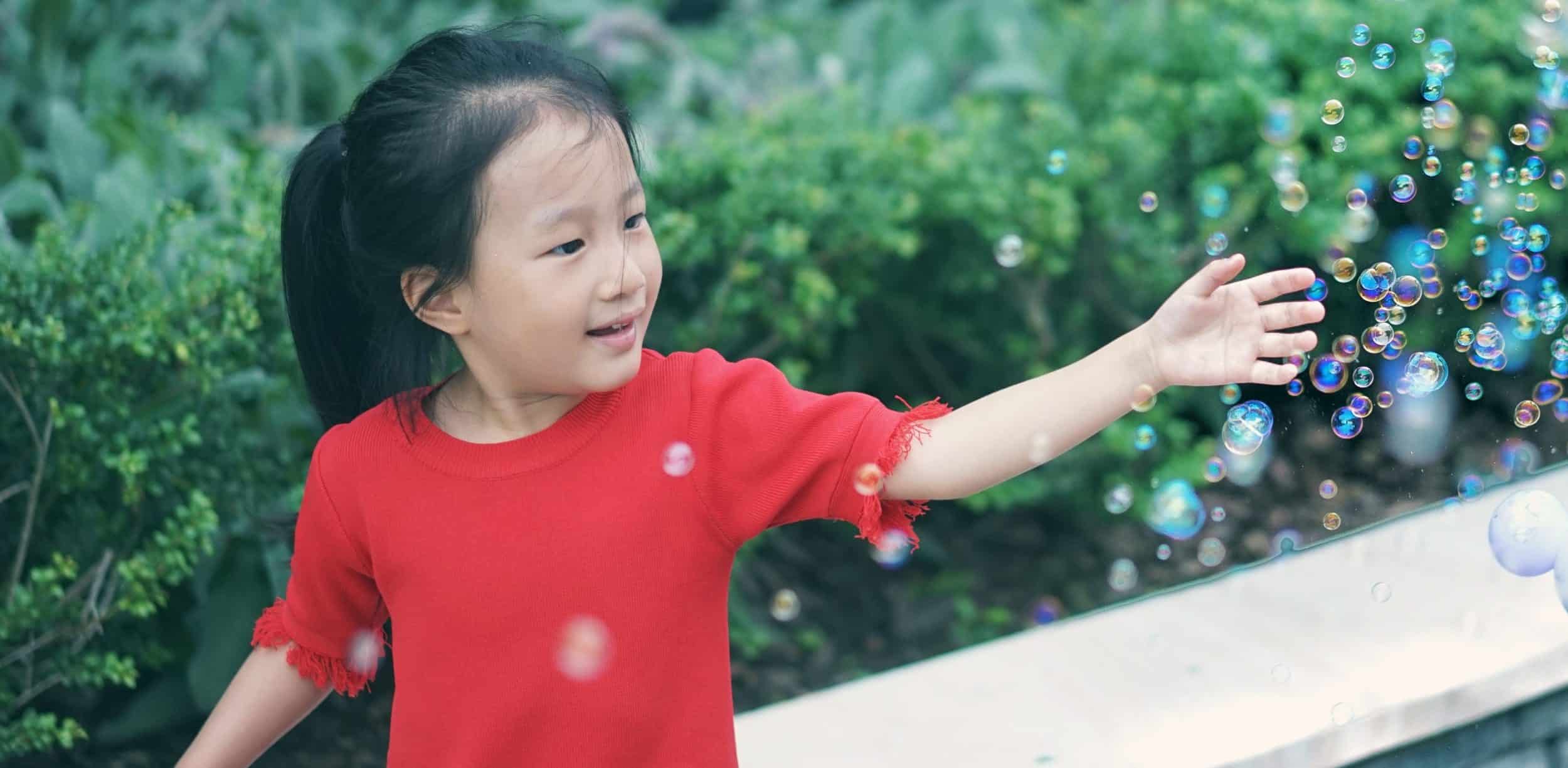 preschool student playing with bubbles
