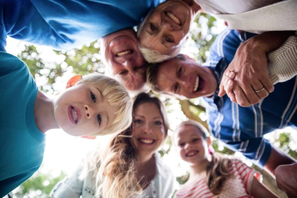 Happy family looking down at camera.