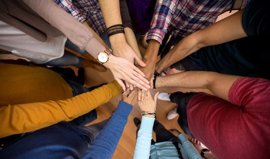 Team member hands in huddle