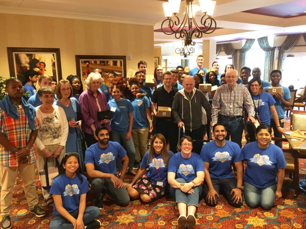 Group of 40+ volunteers, ages 18-98, after volunteering to prepare 300 care packages for US troops and 200 packages for local homeless.