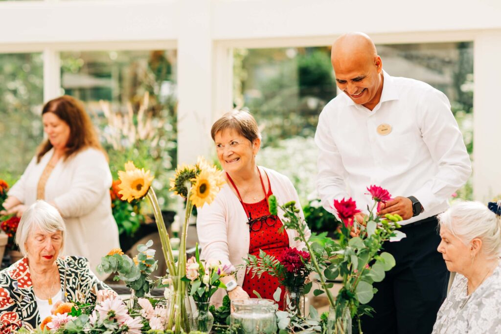 elderly residents and caretakers gardening