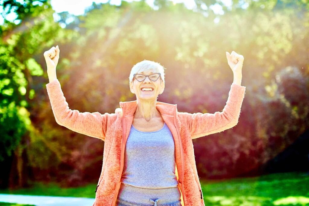 woman raising arms in victory