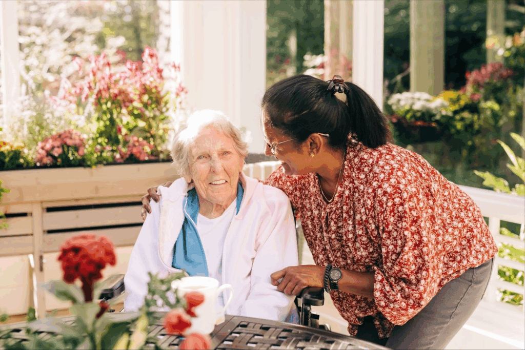 old woman sitting while another woman smiles at her