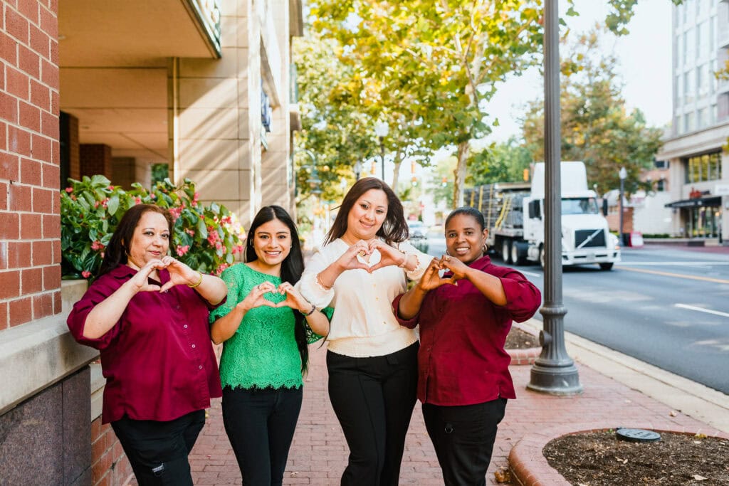 group of women holding heart signs with their hands