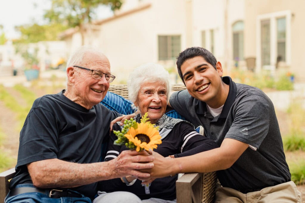 old couple with young man holding sunflower