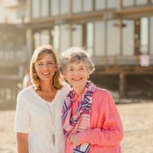 Senior mother and adult daughter taking a stroll at the beach