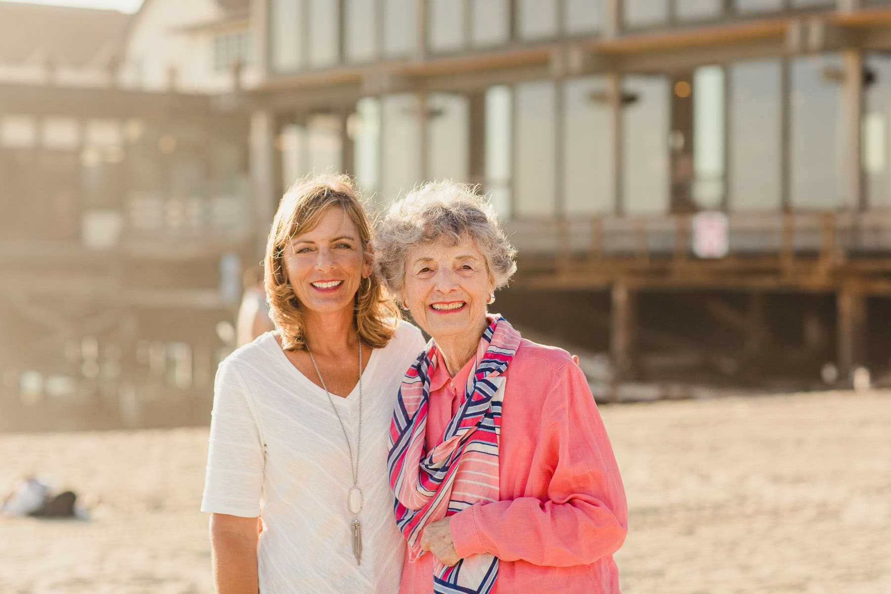 Senior mother and adult daughter taking a stroll at the beach