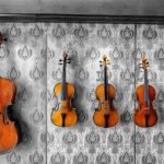 cello and violins hanging on a wall